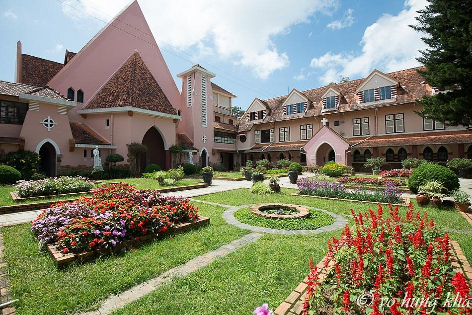 Pink facade of the church with flower beds